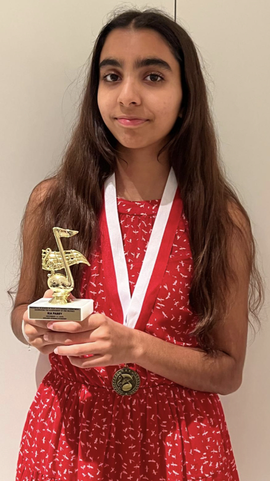 Student Ria holding trophy